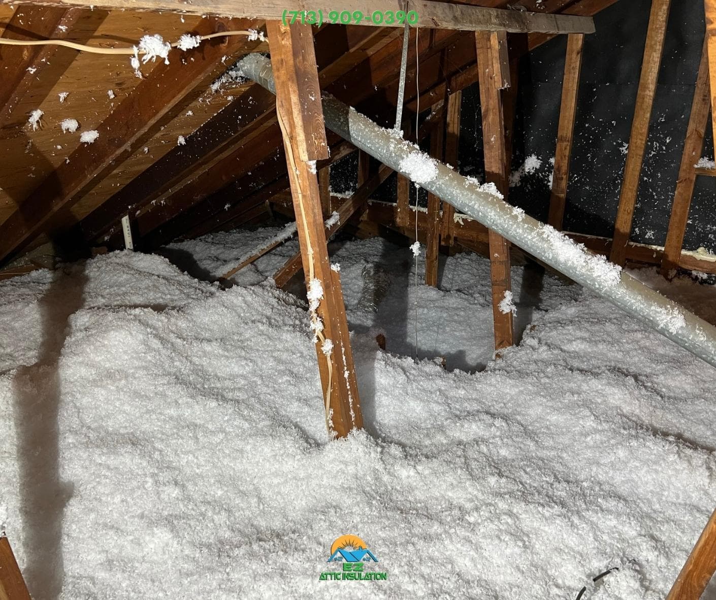 Blown-in insulation being distributed across attic framing