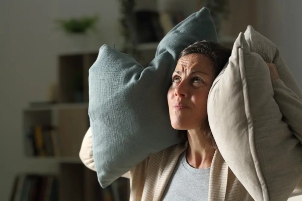 Woman hearing too much noise from neighbors due to poor insulation.