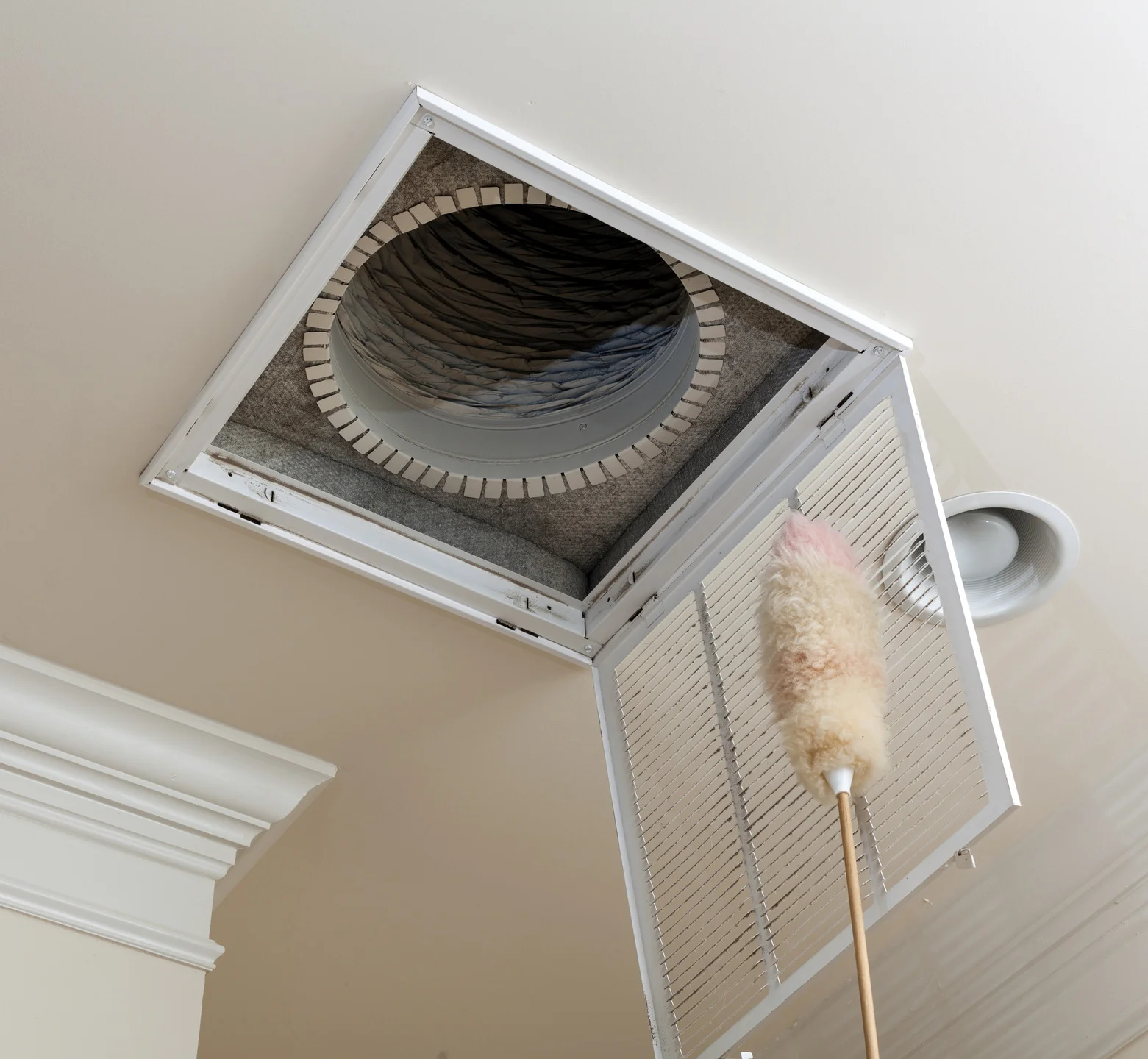 a duster cleaning an air duct vent