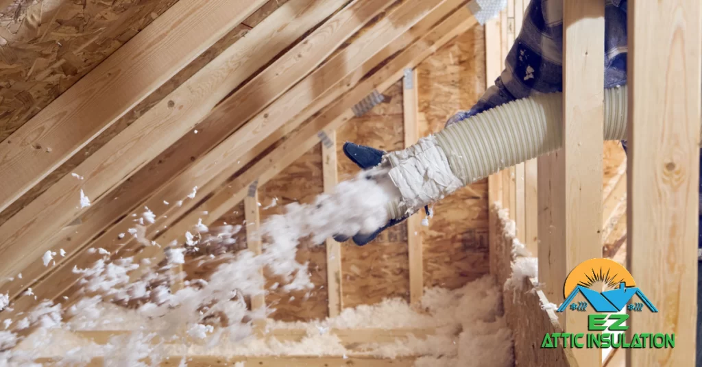 Attic insulation expert installing blow-in fiberglass insulation.